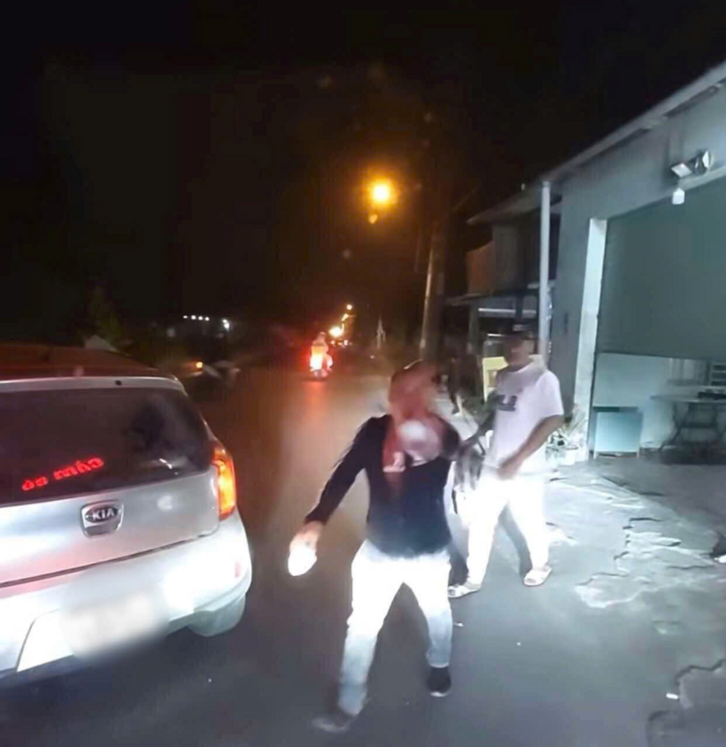 Hình ảnh ghi lại nhóm người ném đá vào ô tô ở Củ Chi (TP.HCM) gây xôn xao trên mạng xã hội. Ảnh: Lao Động