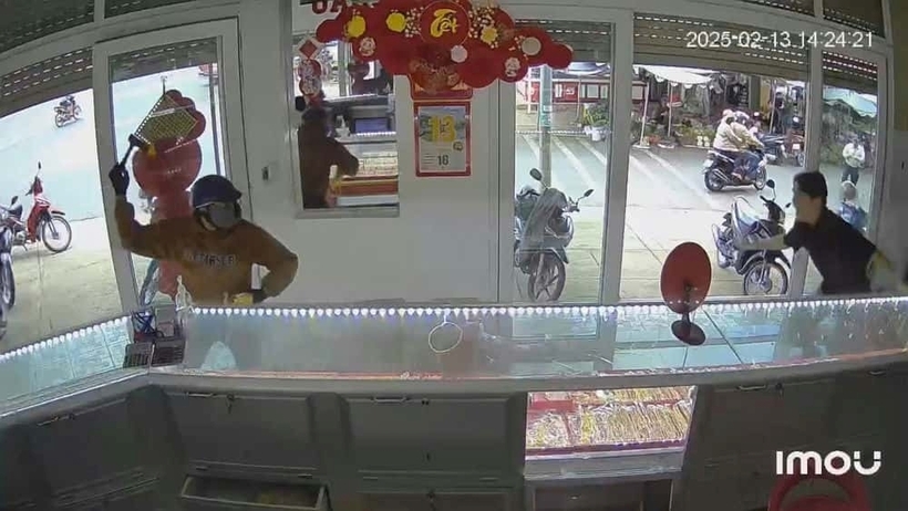 Chung cầm búa đập vỡ tủ kính rồi vơ vét, lấy nhiều trang sức bằng vàng. Ảnh: Lao động