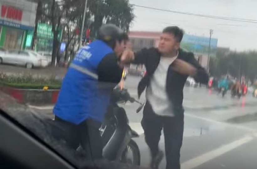 Người đàn ông liên tục đấm vào mặt người đi xe máy. Ảnh: Báo Giao thông