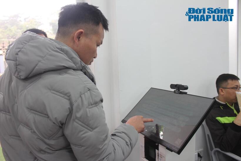 Người dân đăng ký lấy số thứ tự điền vào mẫu đơn được phát