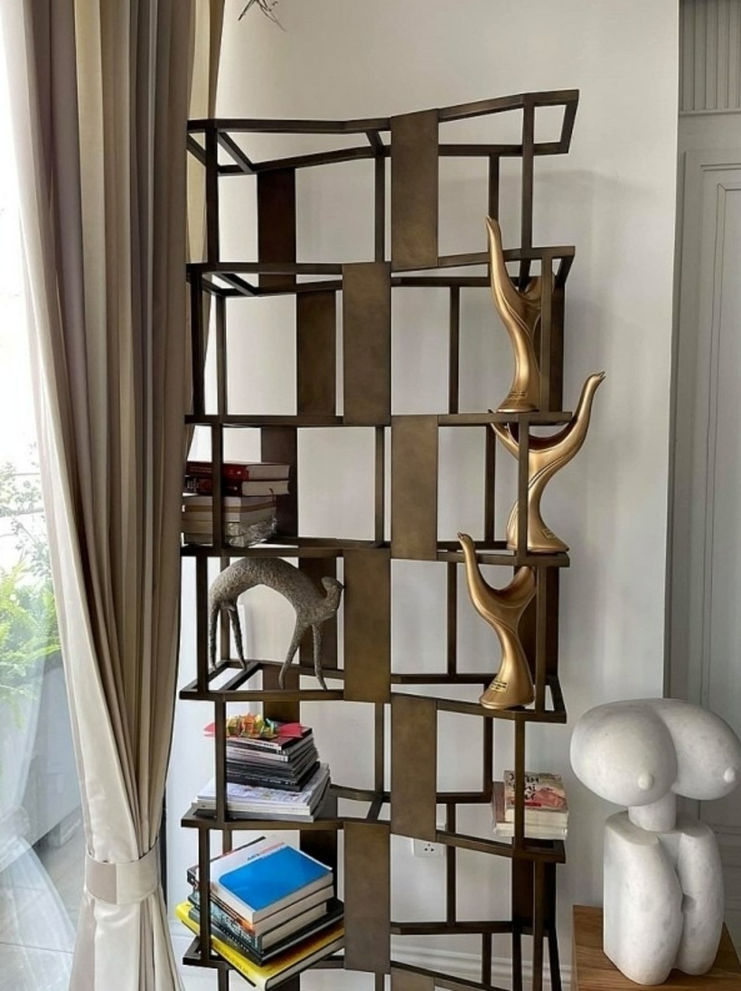 Trong nhà Tùng Dương đặt nhiều kệ, tủ gỗ, để trưng bày đồ. Trong ảnh là một kệ sách độc đáo với các chi tiết trang trí tinh xảo, là nơi trưng bày những cuốn sách yêu thích của Tùng Dương cùng những chiếc cúp quý giá.