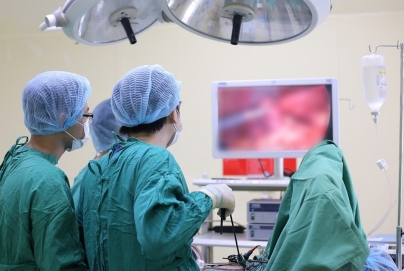 Các bác sĩ tiến hành phẫu thuật cho nữ bệnh nhân. Ảnh: Tiền Phong