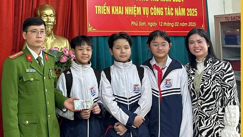 Các học sinh cùng cô giáo đến giao lại số tiền nhặt được cho cơ quan công an. (Ảnh: Công an phường Phú Sơn)