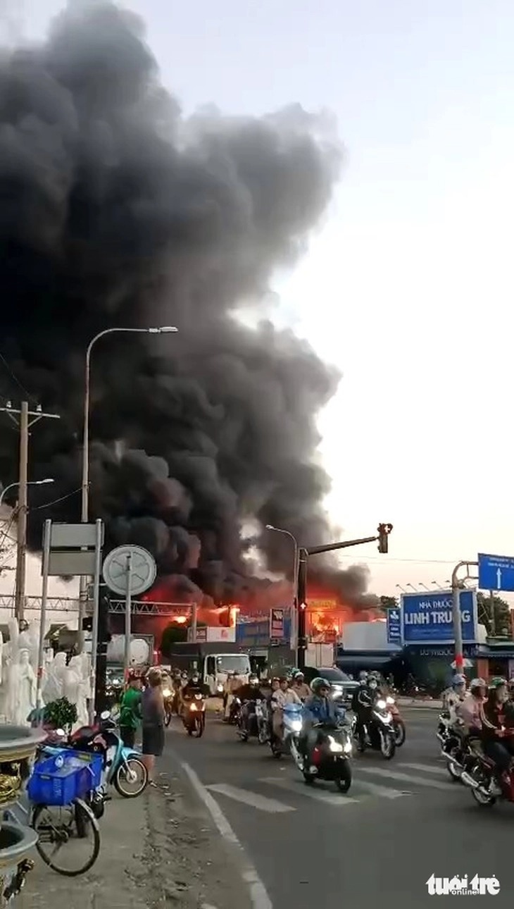 Đám cháy bùng phát mạnh, tạo cột khói cao hàng chục mét kèm theo nhiều tiếng nổ. Ảnh: Báo Tuổi trẻ.