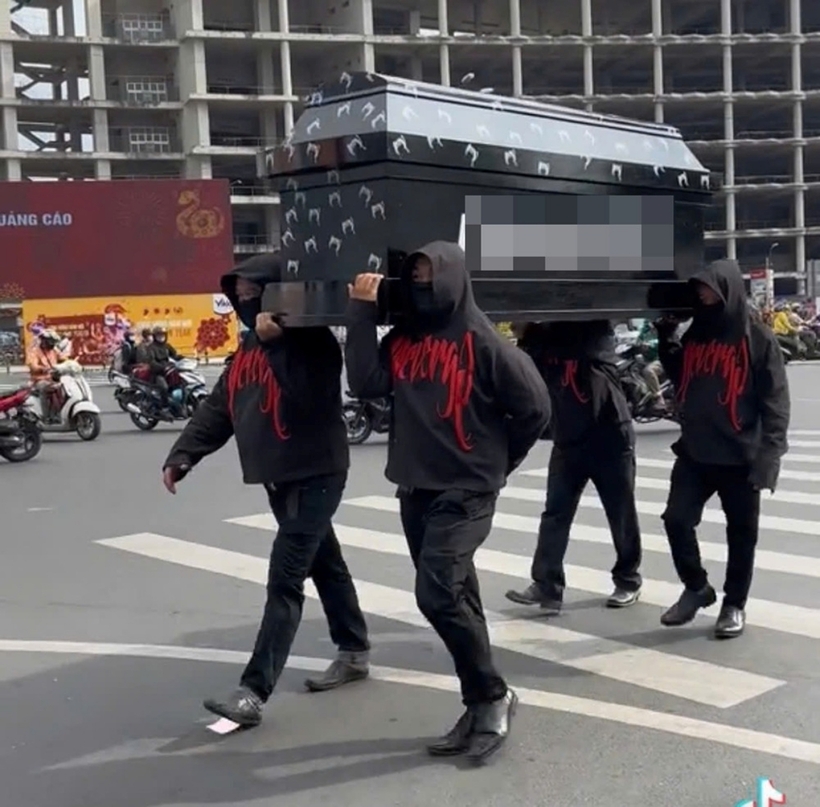Nhóm người mặc đồ đen khiêng quan tài diễu phố ở chợ Bến Thành. Ảnh: VietNamNet