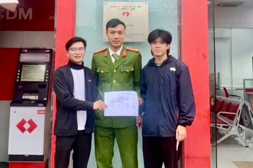 Anh Q. (bên trái) làm thủ tục chuyển khoản, trả lại số tiền chuyển nhầm cho anh T. dưới sự chứng kiến, hỗ trợ của công an. Ảnh: Dân Trí