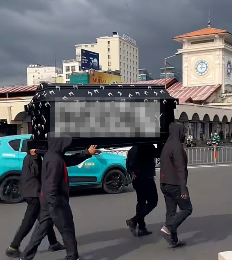 Nhóm người khiêng vác "quan tài" trước chợ Bến Thành. Ảnh: Thanh Niên