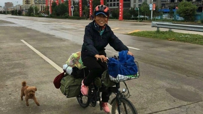 Chú chó cưng tên Xili đã đồng hành cùng bà Li trong hành trình đạp xe khắp Trung Quốc. Ảnh: CNN