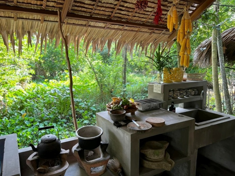 Một khu bếp được xây dựng theo phong cách xưa với ấm, nồi đều nấu bằng lò than.