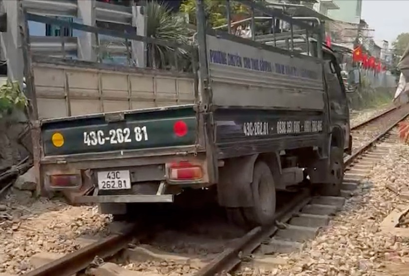 Bánh xe tải kẹt lại trên đường ray xe lửa. (Ảnh: VNE)