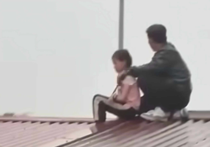 Đối tượng Phan Văn Tuấn đang khống chế cháu bé làm con tin. Ảnh: Người Lao Động