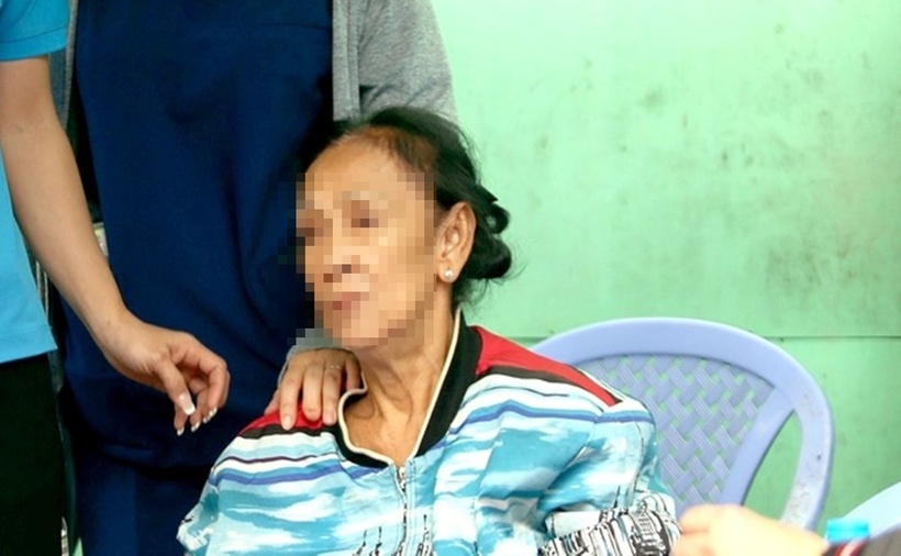 Bà T.T.C như người mất hồn, ngồi khóc, nhìn về phía căn nhà bị cháy của mình. (Ảnh: Tuổi trẻ)