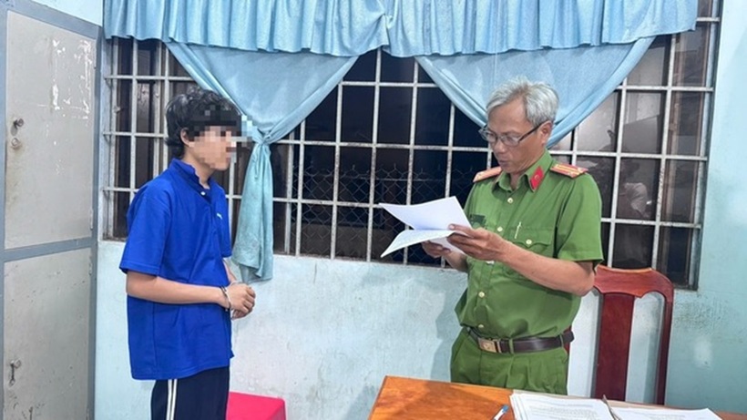 Công an đọc lệnh bắt giữ T. Ảnh: Người lao động