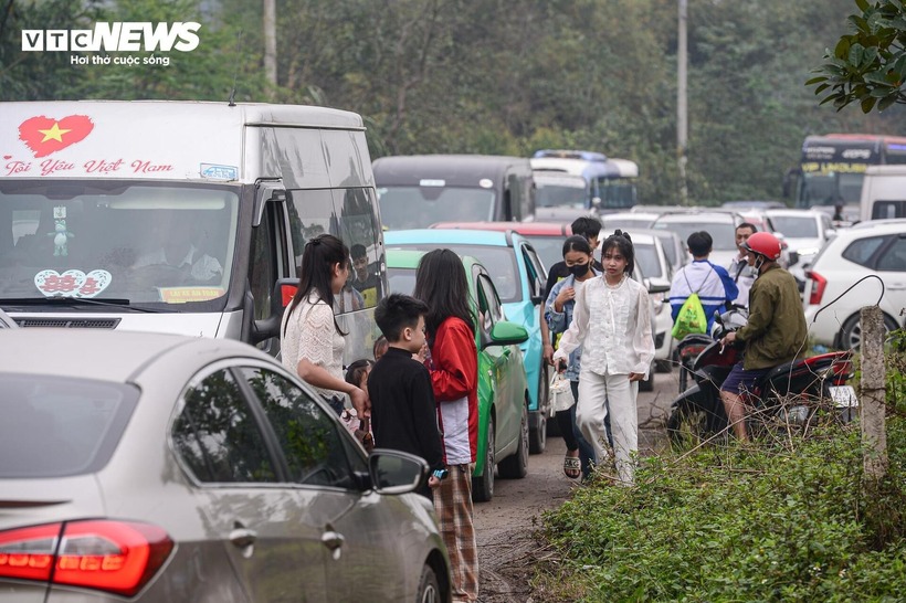Không ít người phải đi bộ quãng đường từ 2-3 km, len lỏi qua các con đường nhỏ, ngõ xóm hoặc men theo các lối tắt để rút ngắn quãng đường đến đền. Đến gần 12h, tình trạng giao thông tại nhiều khu vực dẫn vào Đền Hùng vẫn chưa được cải thiện.