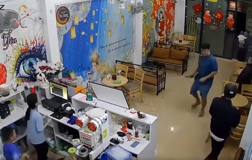 Người đàn ông cầm gậy xông vào đập phá quán trà. Ảnh: Báo Lao Động.