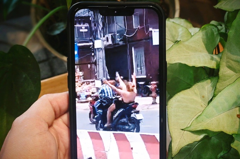 Cô gái buông hai tay, nhảy múa khi chạy xe máy. (Ảnh: Dân trí)