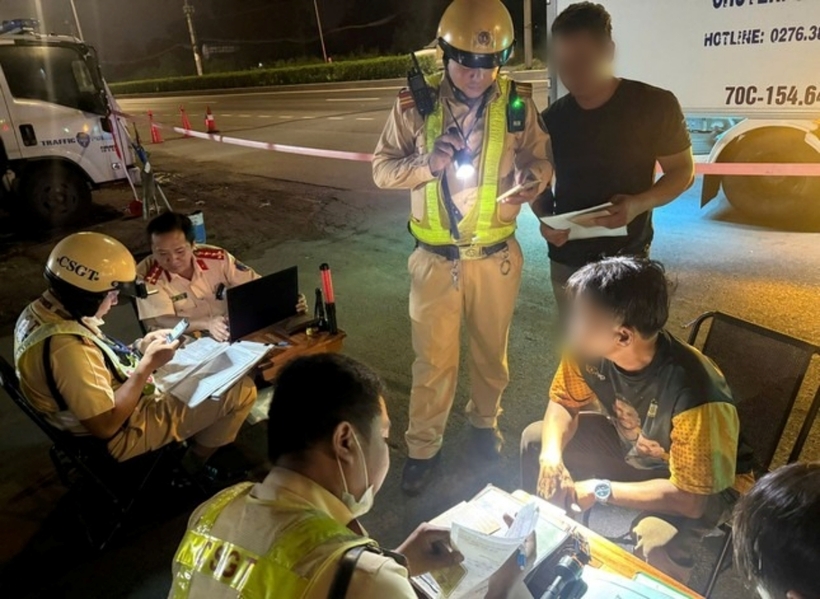 Lực lượng CSGT lập biên bản các tài xế ô tô chạy xe quá tốc độ. Ảnh: Tiền Phong