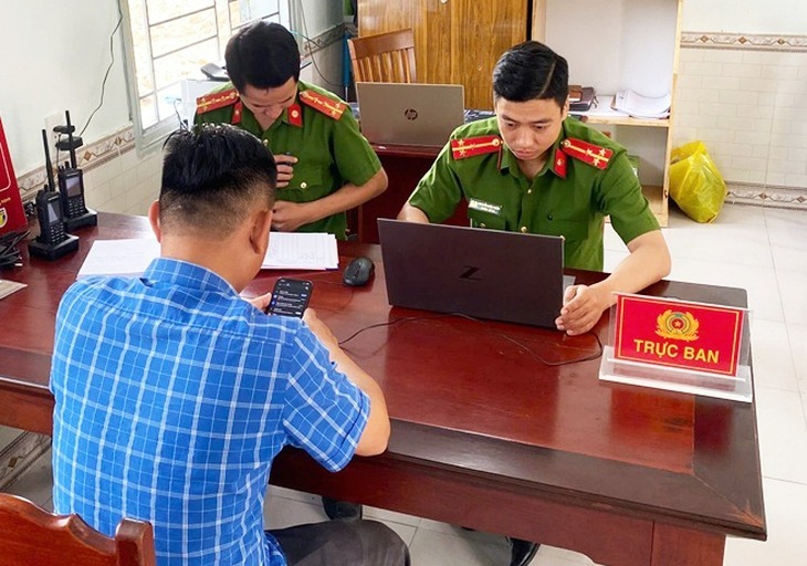 Anh Hòa làm việc với Công an phường Điện Minh để đến ngân hàng trả lại tiền. (Ảnh: Tuổi trẻ)