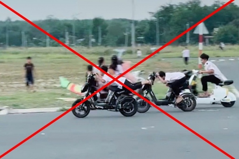 Nhóm học sinh sử dụng xe đạp điện để đua với nhau, không đội nón bảo hiểm, nằm trên yên xe. Ảnh: Báo Công an Nhân dân.