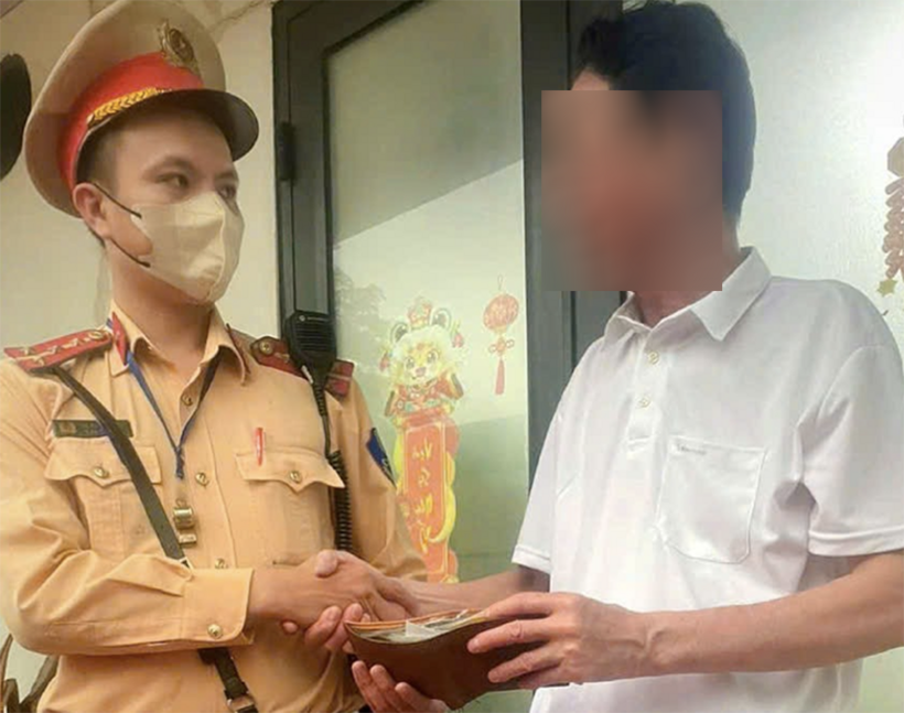 CSGT trao trả chiếc ví cho ông H. (Ảnh: Công an)