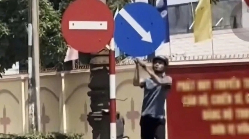 Người đàn ông vác búa tạ đập phá biển báo giao thông tại Buôn Ma Thuột. Ảnh: Pháp luật TP.HCM
