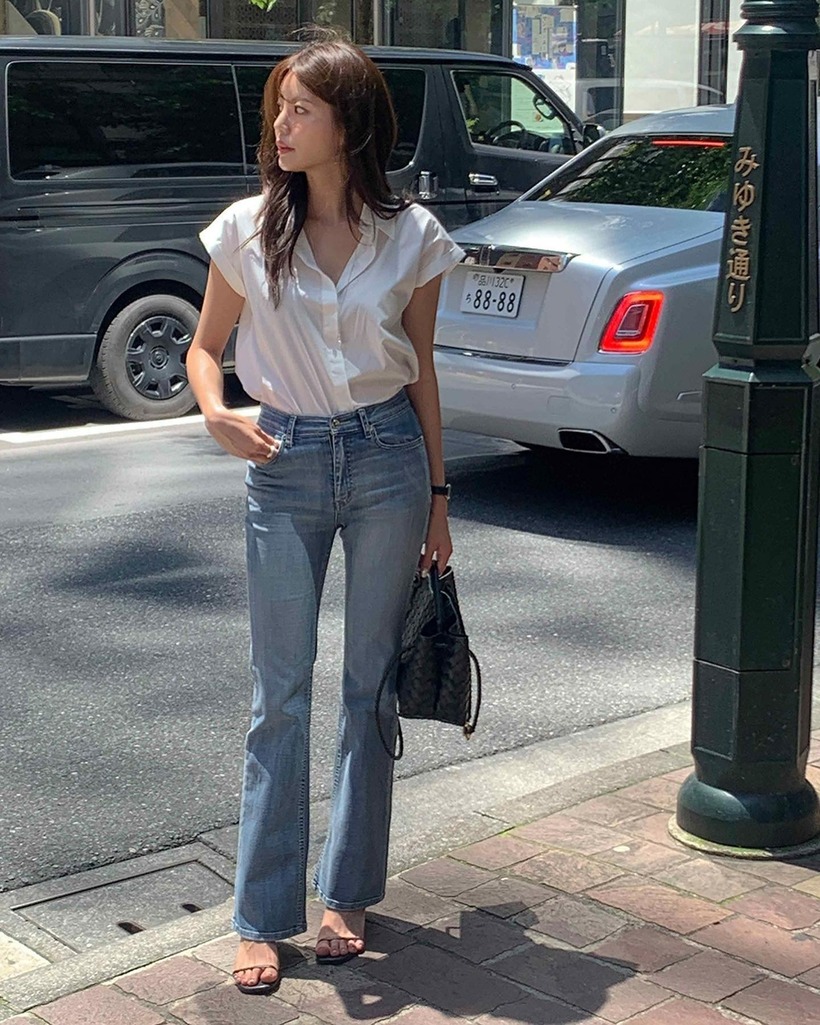 Sự kết hợp giữa áo sơ mi trắng và quần jeans xanh luôn đúng. Công thức này thanh lịch và "hack" tuổi hiệu quả. Một chiếc túi xách màu đen sẽ giúp chị em hoàn thiện bộ đồ tinh tế. Ngoài ra, giày màu đen cũng là mảnh ghép hoàn hảo của outfit.