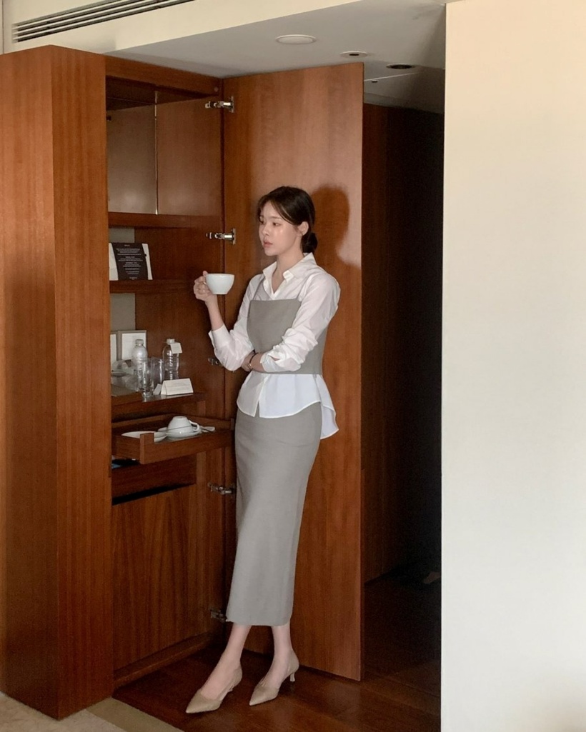 Bộ trang phục layer kết hợp giữa áo sơ mi, áo hai dây và chân váy suông hứa hẹn mang đến một làn gió mới cho phong cách làm việc nơi công sở. Với gam màu xám và trắng chủ đạo, set đồ không chỉ tạo ra vẻ đẹp thanh lịch mà còn thể hiện sự tinh tế và nhã nhặn cho người mặc.