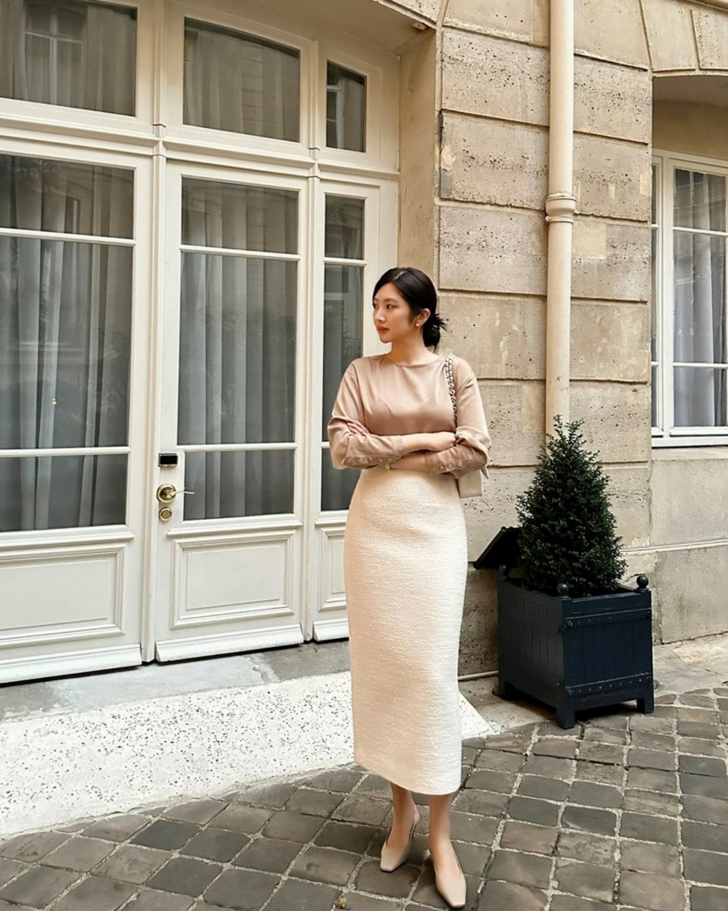 Áo blouse màu be kết hợp với chân váy trắng là những món đồ mang tính sang trọng và nữ tính. Nhờ vào sự kết hợp này, các chị em dễ dàng toả sáng với phong cách thời trang tinh tế. Đặc biệt, đôi giày mũi vuông không chỉ phù hợp mà còn hoàn thiện một cách hoàn hảo cho tổng thể trang phục đầy cuốn hút.