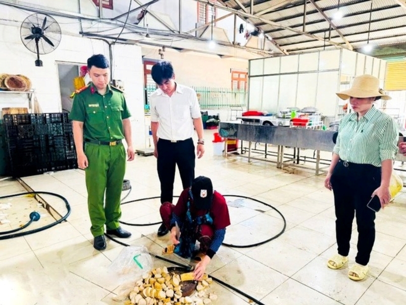 Nhân viên cơ sở tiêu hủy khoảng 5,4 kg chả chiên chứa hàn the dưới sự chứng kiến của đoàn kiểm tra. Ảnh: Người Đưa Tin