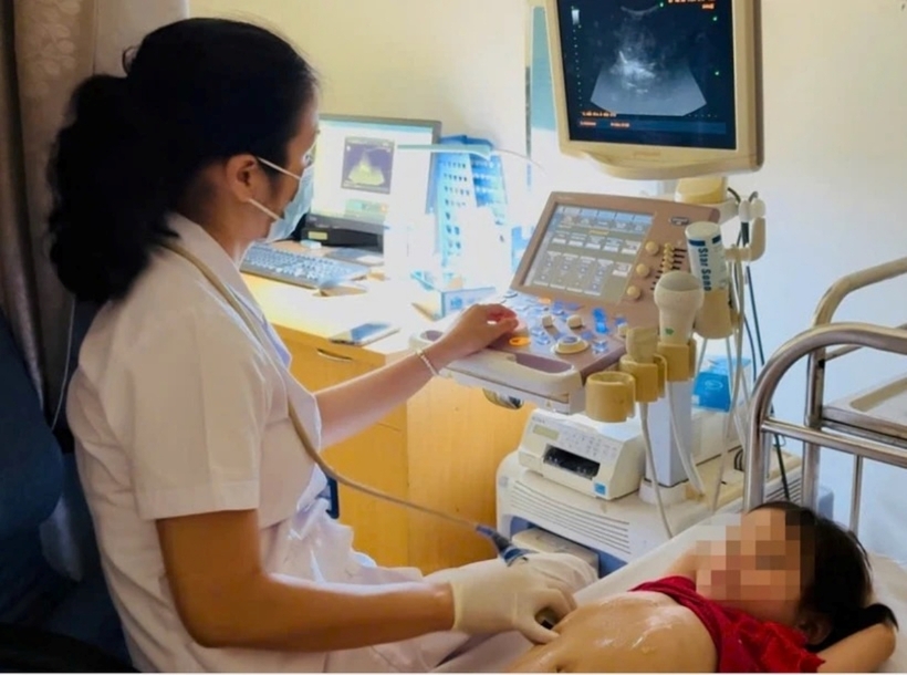 Bác sĩ siêu âm, kiểm tra cho bé gái. Ảnh: VietnamPlus