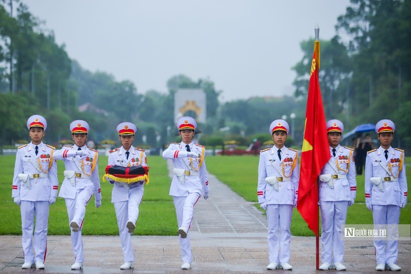 Ba chiến sĩ tiến về cột cờ thực hiện nghi thức treo cờ rủ.