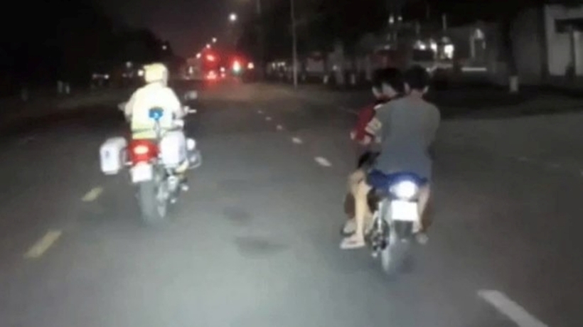 Một nhóm 3 thanh, thiếu niên không đội mũ bảo hiểm, đi chung trên một xe máy. Ảnh: Lao Động
