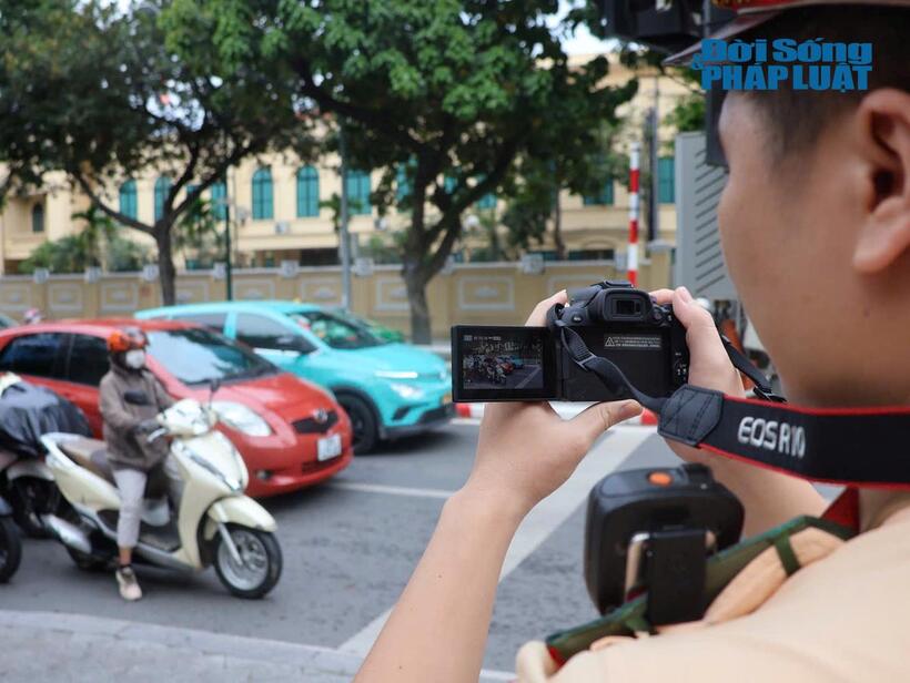 CSGT sửa dụng thiết bị nghiệp vụ để ghi hình vi phạm. Sau khi phát hiện vi phạm, sẽ báo cho tổ công tác dừng xe để xử lý