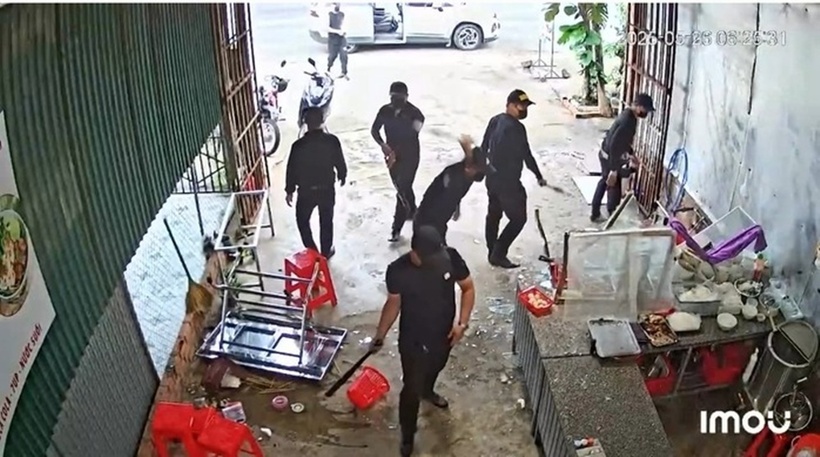 Nhóm đối tượng gồm 7 người mặc áo đen xông vào quán, một số đối tượng dùng gậy liên tiếp đập vào tủ hàng hóa. Ảnh: Báo Người lao động.