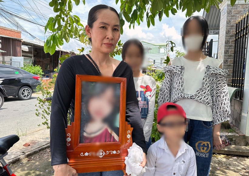 Bà Hiền cùng các con mang di ảnh con gái đến buổi làm việc. (Ảnh: VietnamNet)