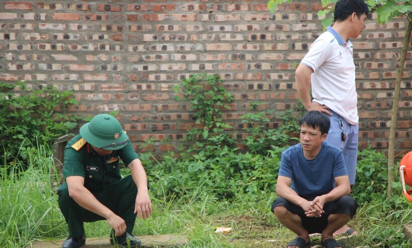 Anh Nguyễn Duy Tiến dõi theo lực lượng chức năng tìm kiếm em trai tại hiện trường vụ việc. Ảnh: VietNamNet