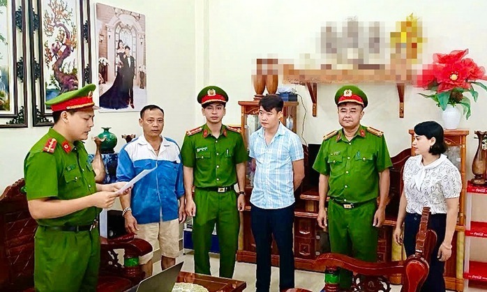 Cơ quan Cảnh sát điều tra Công an tỉnh Quảng Bình tống đạt quyết định khởi tố, lệnh bắt tạm giam đối với Lê Quang Hải (người mặc áo sọc xanh) - Chủ sở hữu Công ty CP IQ Group. Ảnh: Người lao động