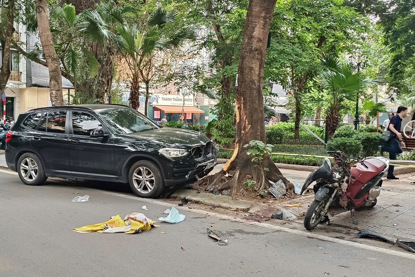 Phần đầu chiếc ô tô BMW X3 nằm trên vỉa hè và hư hỏng nặng. Xe máy bị biến dạng, nhiều mảnh vỡ văng khắp nơi. (Ảnh: Dân trí)