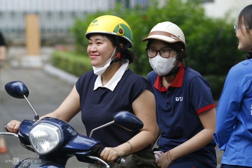 Học sinh được mẹ đưa tới trường thi, sáng 4/6. Ảnh: Thanh Hằng