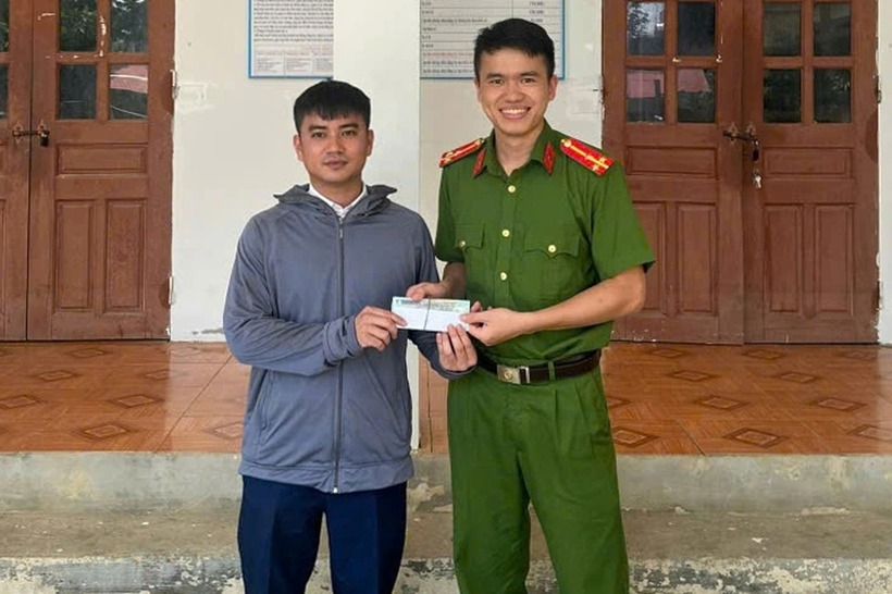 Anh Vũ Xuân Khoản nhận lại số tiền đánh rơi. (Ảnh: Công an Thanh Hóa).
