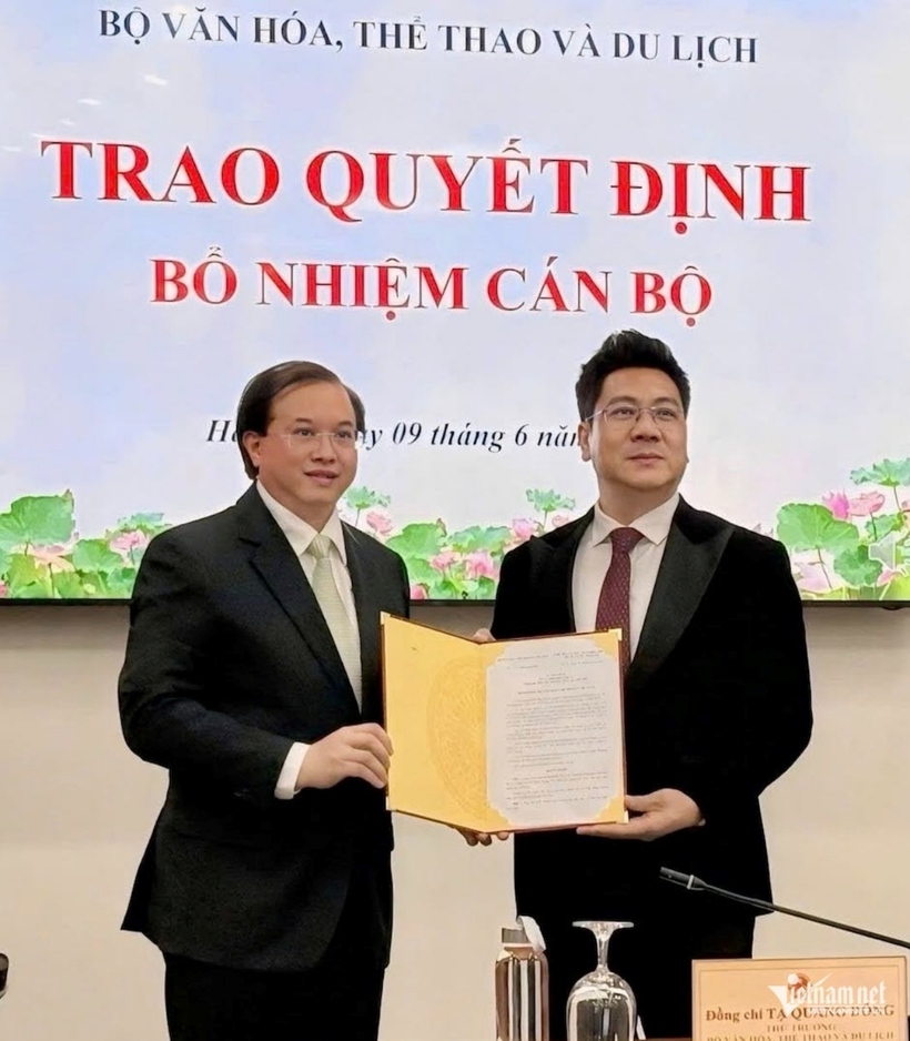 Thứ trưởng Bộ Văn hóa, Thể thao và Du lịch Tạ Quang Đông trao quyết định bổ nhiệm Giám đốc Học viện Âm nhạc Quốc gia Việt Nam cho NSND Quốc Hưng. Ảnh: VietNamNet