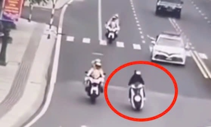 Thanh niên lái xe máy (chở theo người khác) từ phía sau chen vào đoàn xe rồi vượt lên trước. Ảnh: Báo Lao động.