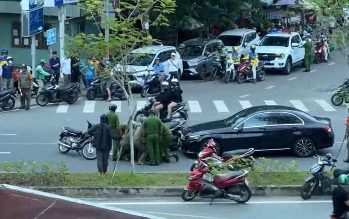 Lực lượng chức năng đến hiện trường khống chế người đàn ông chặn đầu, đập phá xe ô tô. Ảnh: Người lao động