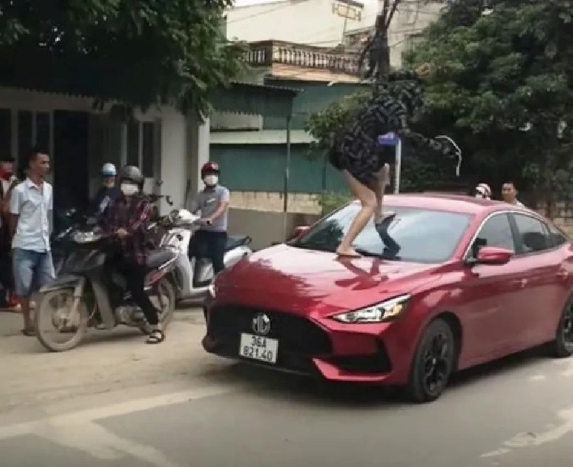 Người phụ nữ 30 tuổi đã lao vào đầu xe ngồi, trèo lên đầu chiếc xe ôtô con, rồi đạp vỡ kính chắn phía trước xe. Ảnh: Vietnamnet.