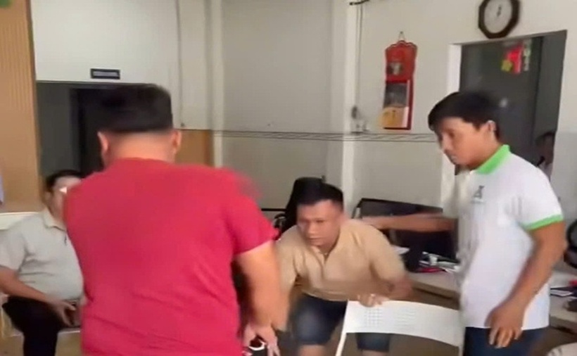 Lực lượng chức năng vào phòng công chứng bắt đối tượng làm giả sổ đỏ. (Ảnh: NLĐ)