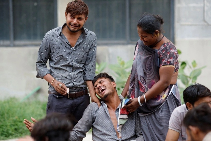 Kalpeshbhqi Patni chờ nhận thi thể em trai Akash Patni. (Ảnh: Reuters
