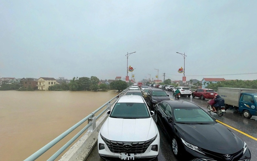 Người dân đưa ô tô lên cầu Kiến Giang, huyện Lệ Thủy để tránh lũ. (Ảnh: Dân trí)