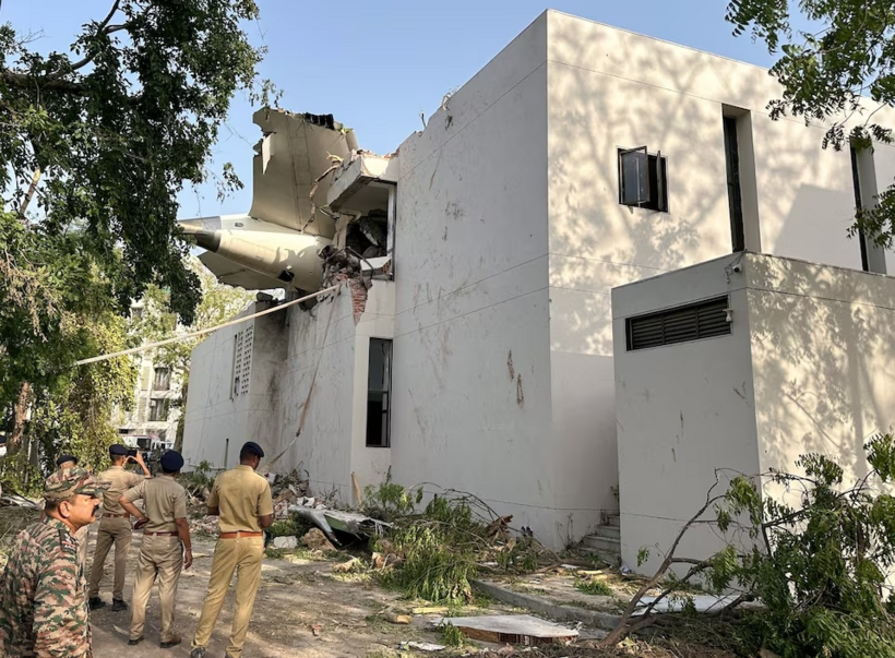 Đuôi của chiếc máy bay bị rơi được nhìn thấy mắc kẹt trên một tòa nhà ở Ahmedabad, Ấn Độ. Ảnh: Reuters.