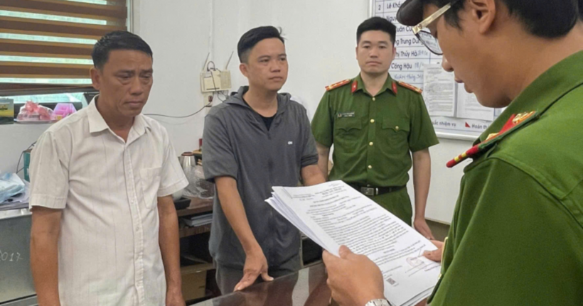 Cơ quan Công an đọc Quyết định khởi tố bị can, bắt tạm giam đối với Nguyễn Văn Đây (áo trắng) và Bùi Yên Khánh (áo xám). (Ảnh: Công an Hòa Bình)