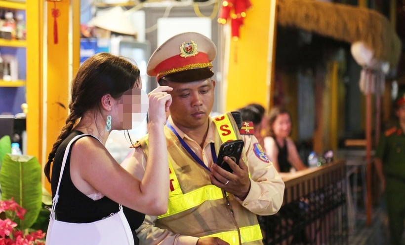 CSGT giải thích cho một nữ du khách nước ngoài về việc không được vào khu vực phố cà phê đường tàu để tránh gây mất an toàn giao thông. (Ảnh: Dân trí)